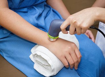Ultrasound in physical therapy - Therapist using ultrasound to treat patient's hand